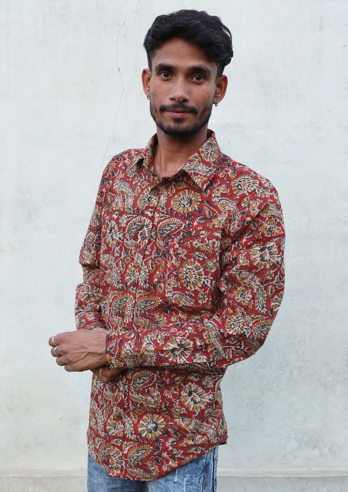 Man wears cotton long sleeve shirt with collar, coconut buttons and one breast pocket