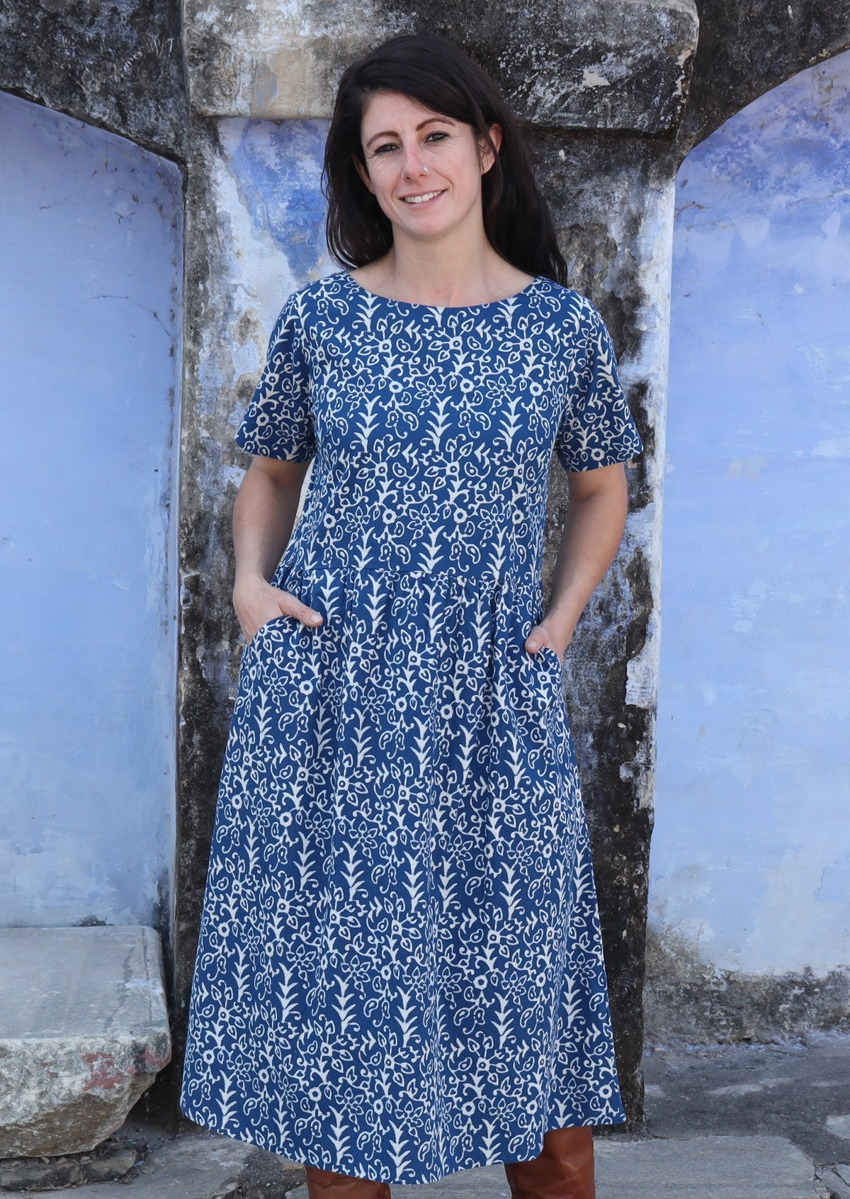 Woman smiling hands in pockets wearing 100% cotton blue and off white Maddison dress