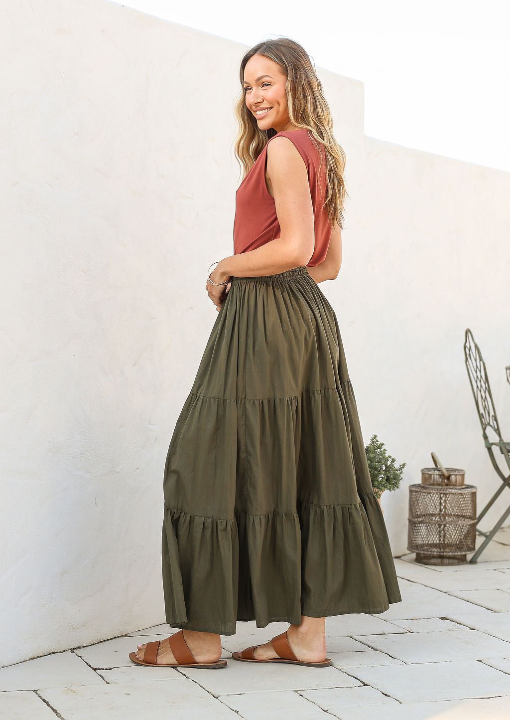 Model wearing a plain olive green cotton skirt with elasticated and drawstring waistband.