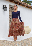 Model wears crinkled cotton skirt with elastic waist and drawstring, paired with long sleeve stretch navy blue top.