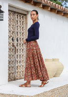 Side pose of model wearing tiered cotton maxi skirt in earthy floral print.