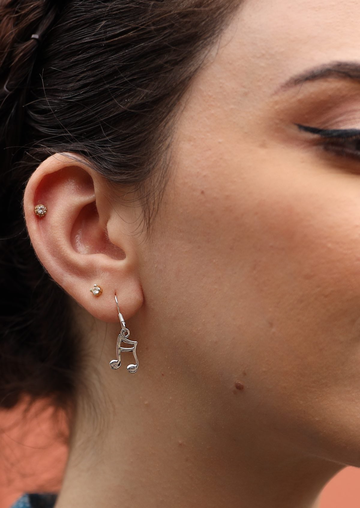 These elegant sterling silver earrings feature delicate music notes suspended from wire hooks