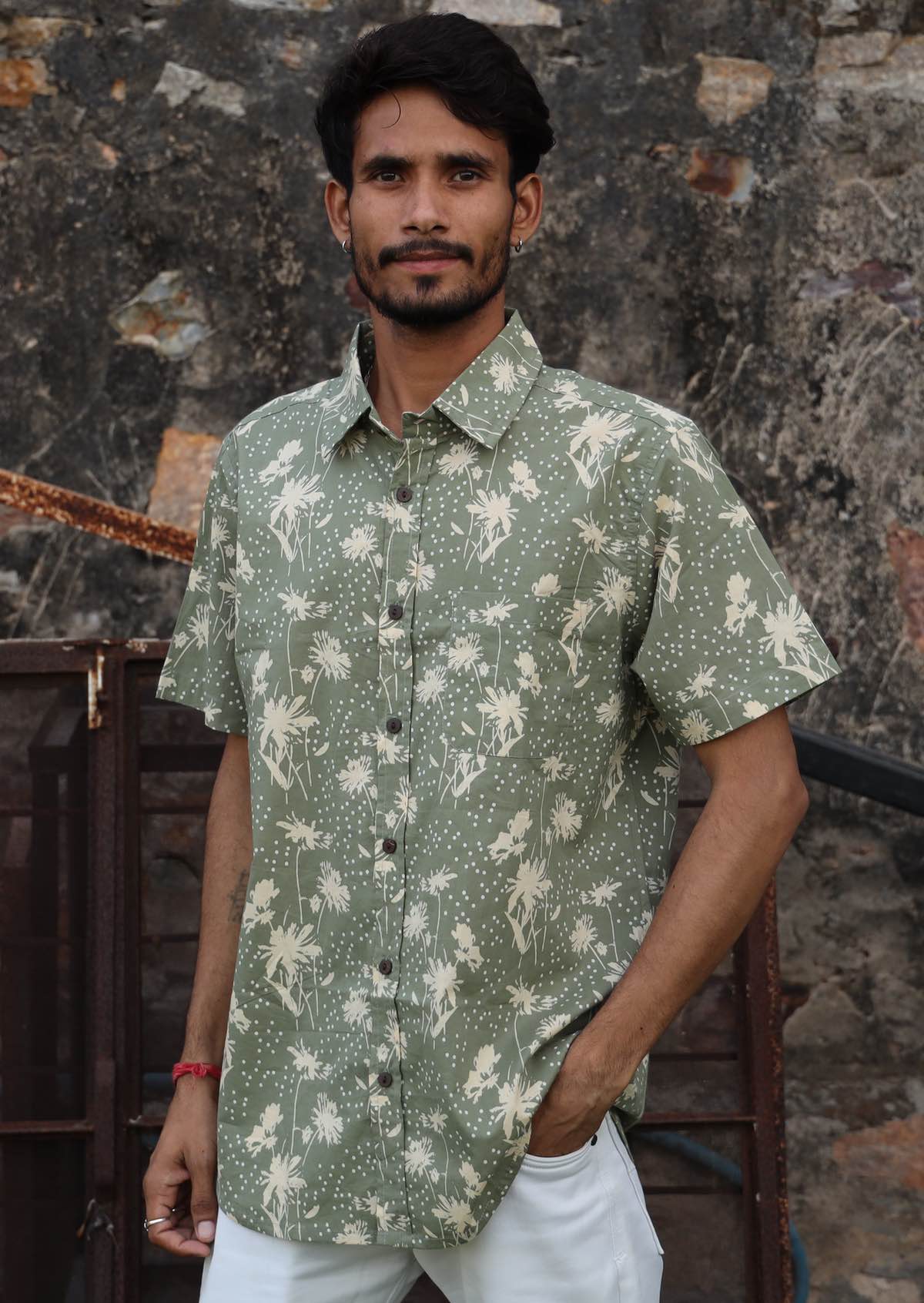 Man wears relaxed fit cotton shirt in pale green with cream florals.