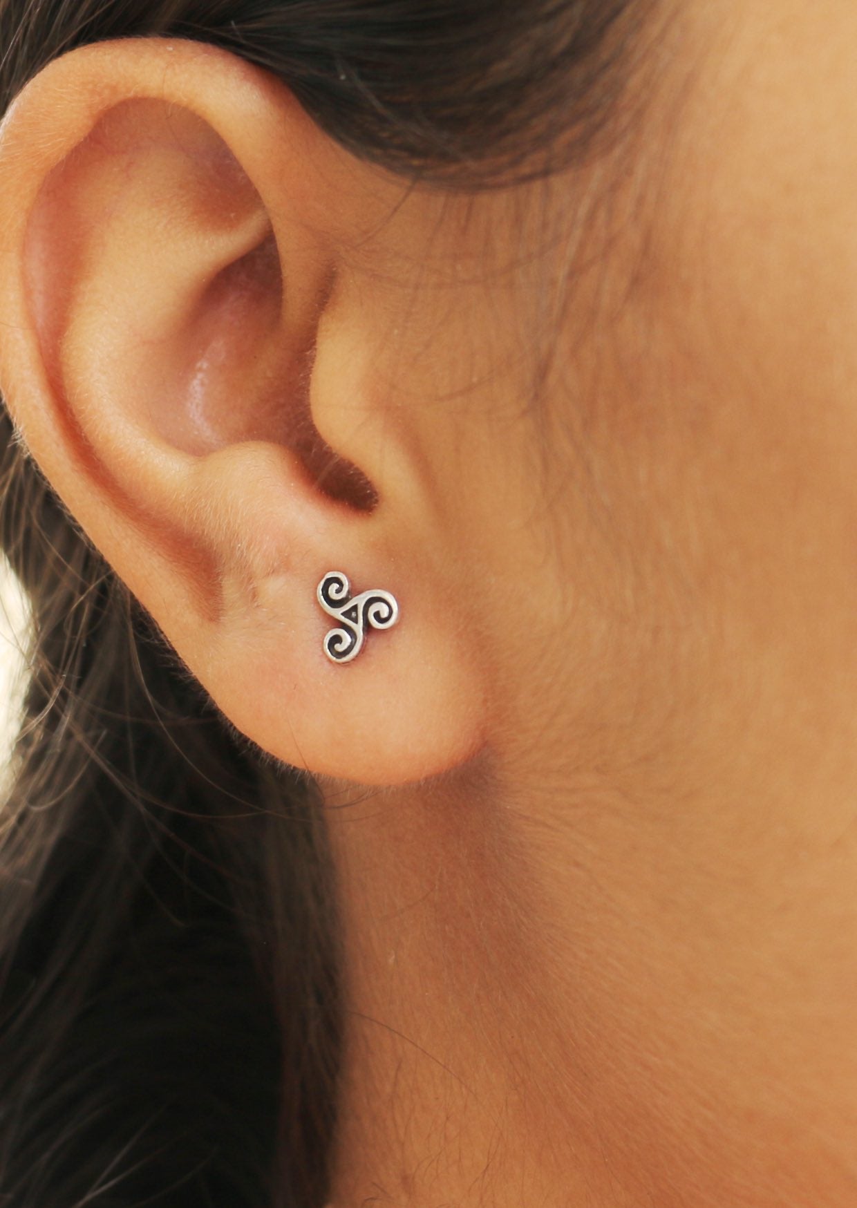 Mini sterling silver Triskele studs with three spirals radiating from the center
