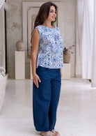 Woman stands slightly sideways wearing a high waisted, wide leg cotton pants with side zipper and pockets.