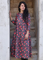 Model with dark hair wearing a 100 percent cotton three tiered midi length dress with blue base and red floral print