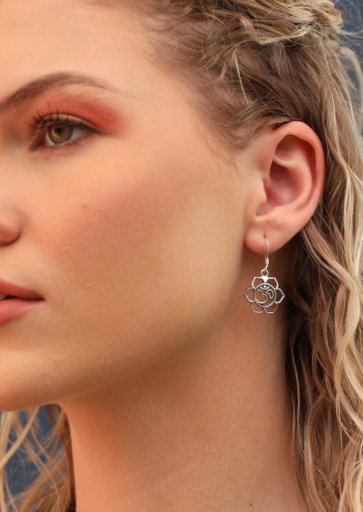 model wearing large silver om design dangly earring