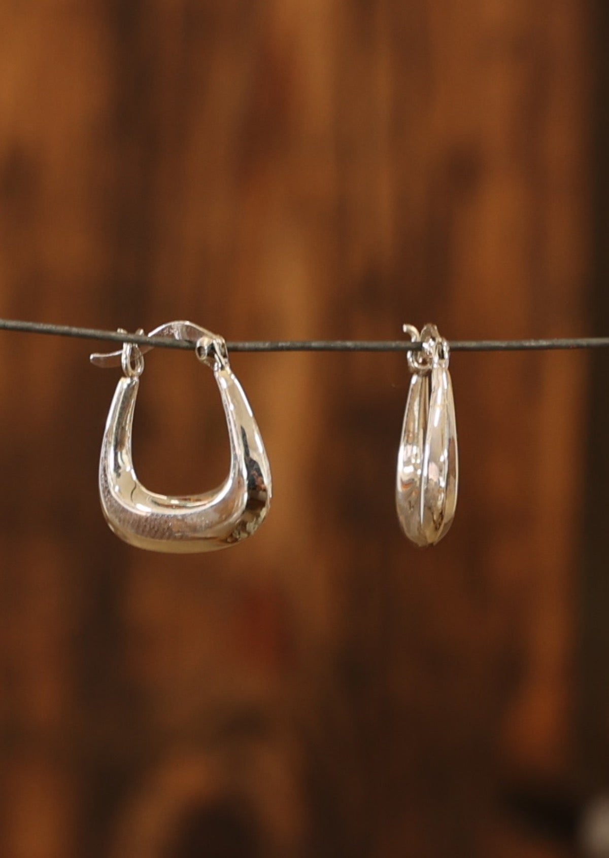 Hinged clasp secures silver square bottomed hoops