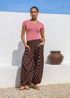 Model wears 100% cotton harem pants with elasticated ankles, wide waistband and hands in deep pockets.