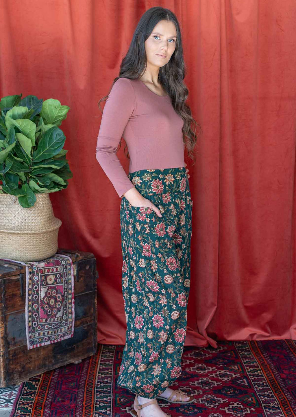 Model pairing floral printed green cotton pants with long sleeved dusty rose top.