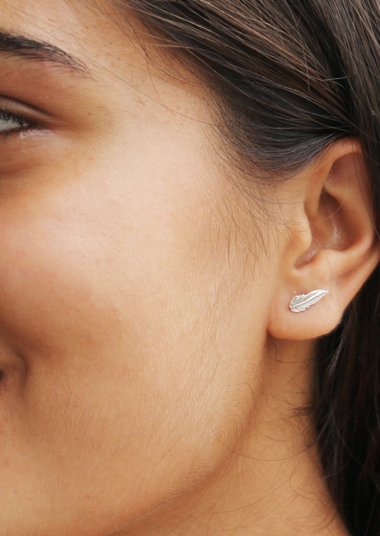 Delicate silver feather shaped studs with fine details and secure butterfly backs