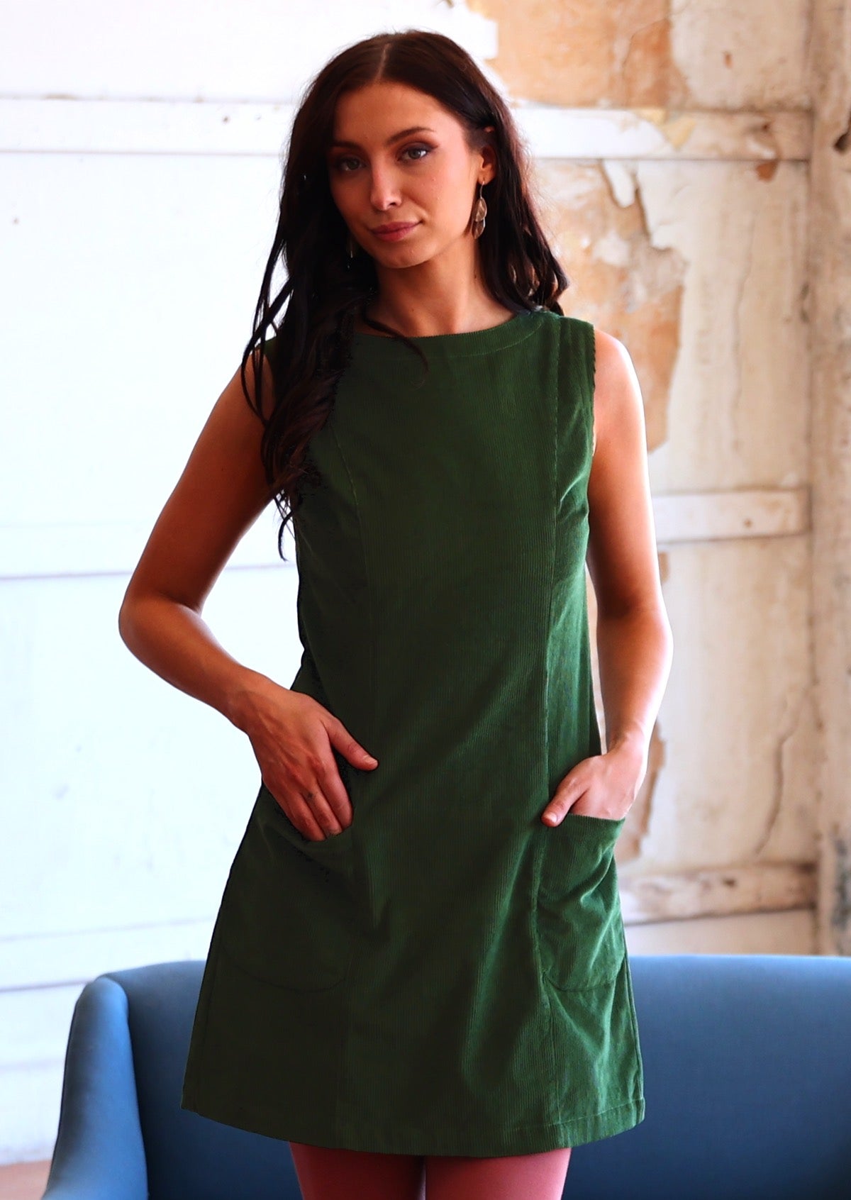 Woman wearing cotton corduroy tunic in Douglas Fir green with boat neck and front pockets