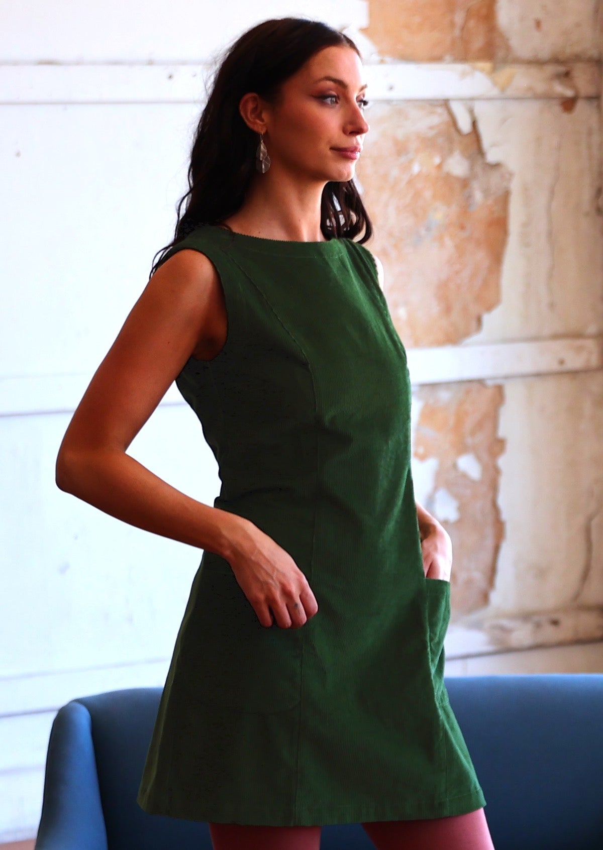Woman wearing green corduroy tunic in with hand in pocket
