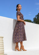 Model wearing 100% cotton relaxed fit dress in dark purple with V neckline, waist tie and pockets.