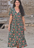 Model wearing 100 percent cotton dark jade green button through v-neck dress with pockets