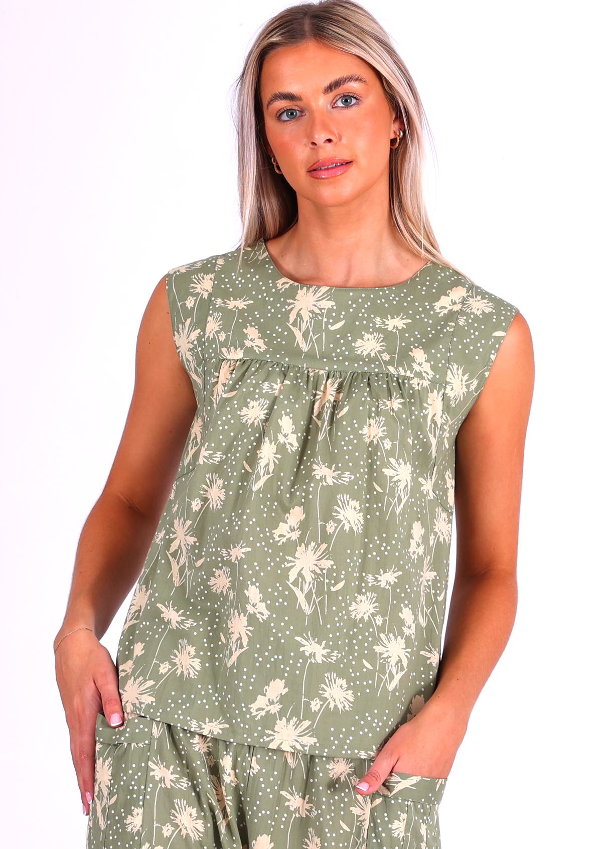 Woman wears cotton top with small gathers under the neckline yoke, both front and back, that gives this top a loose fit