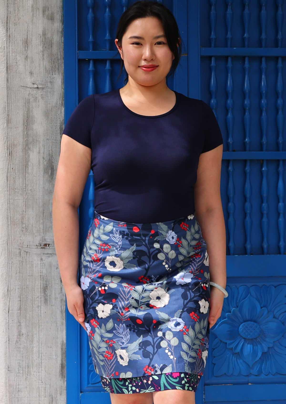 Front image of Model wearing blue floral print  reversible skirt 100 percent cotton knee length skirt.