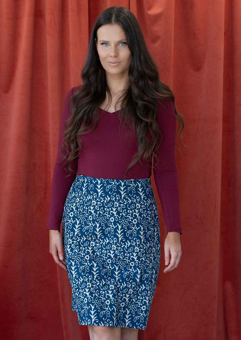 Model wearing blue, floral printed reversible skirt with hidden side zipper.