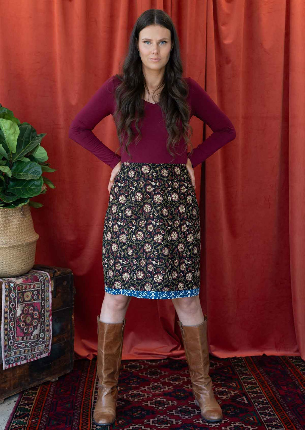 Model wears 100% floral printed reversible skirt in bold maroon and cream floral print on black base.