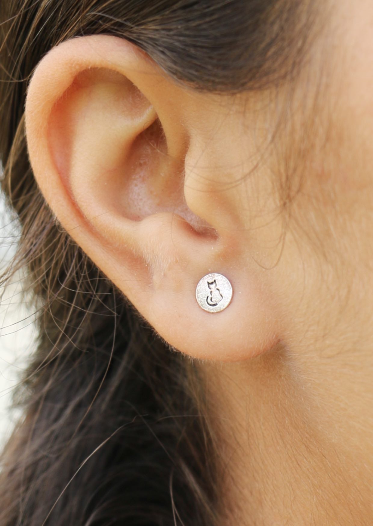 Small round sabrina silver studs featuring a cat silhouette on the front and butterfly backs
