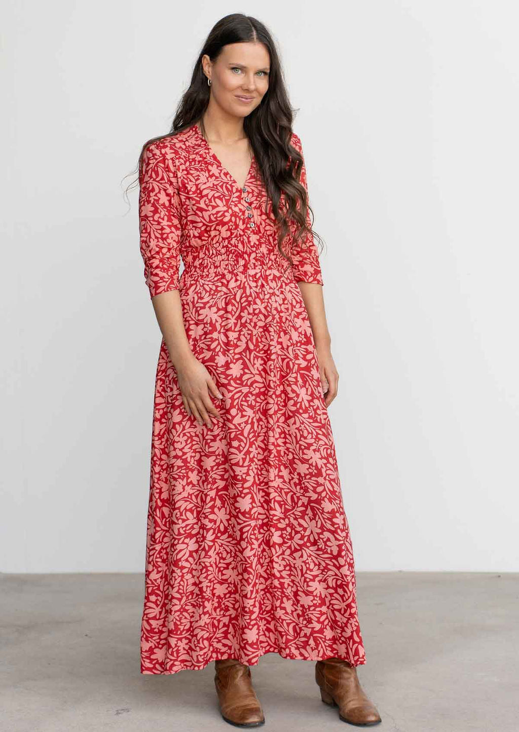 Model wears floaty rayon maxi dress in stunning red and coral floral print