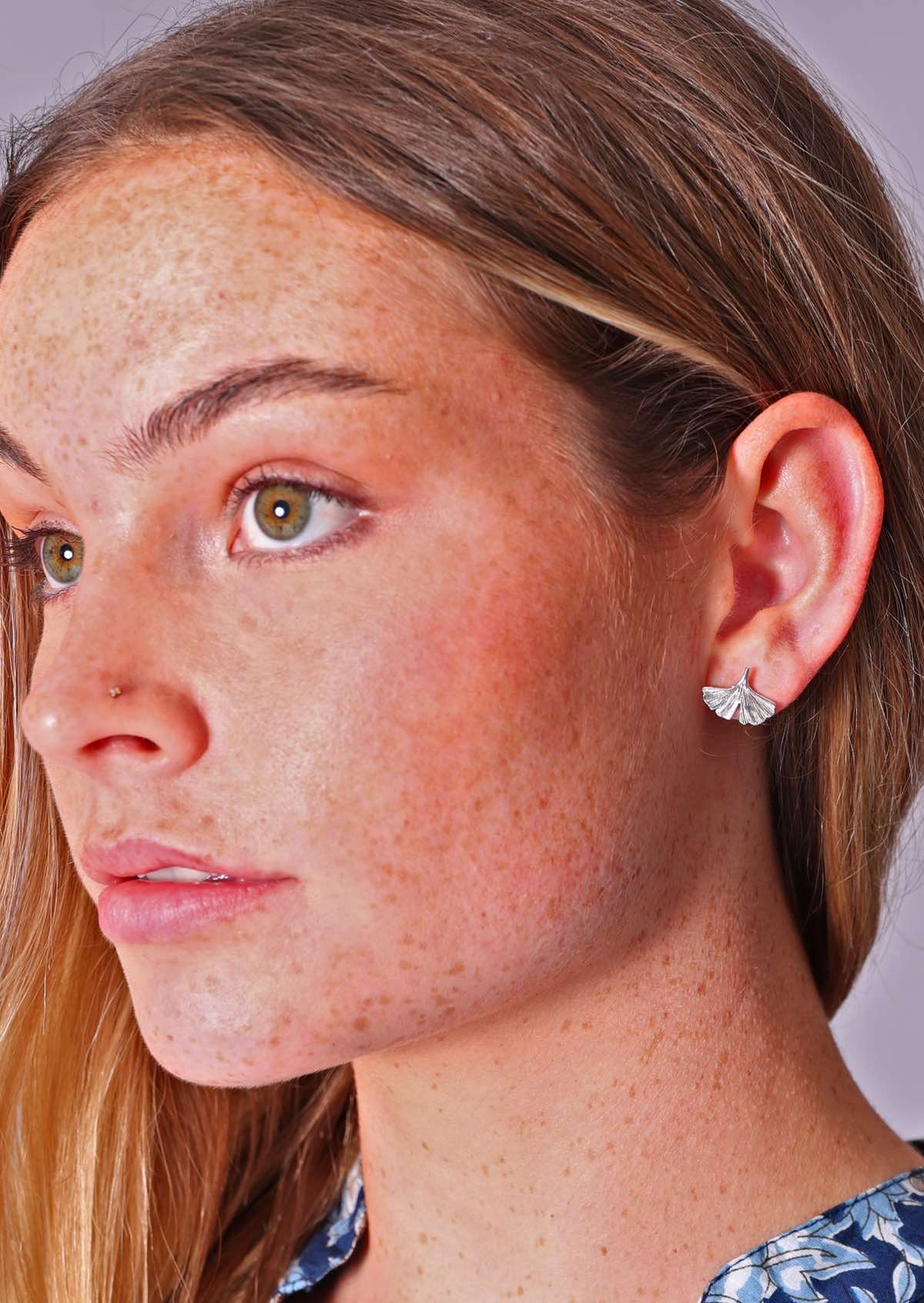 Woman wearing sterling silver ginkgo stud earrings