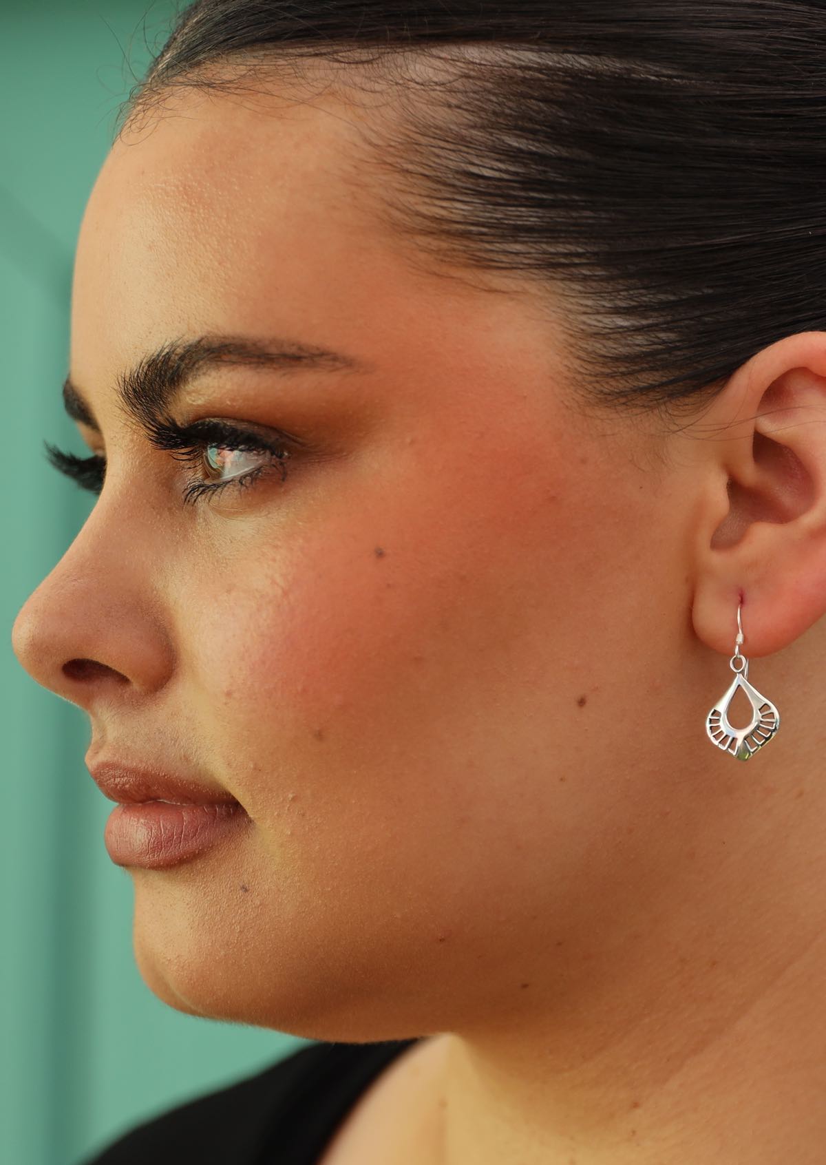 woman with dark hair wearing silver earring art nouveau style