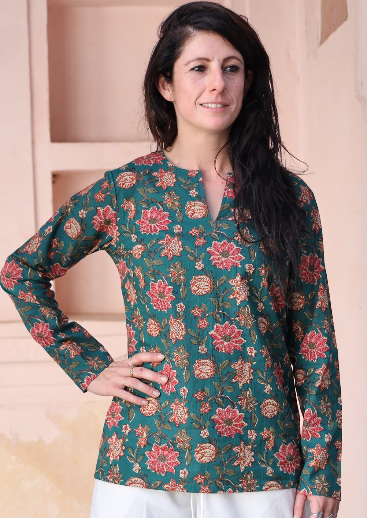 Model poses in cotton long sleeve top with keyhole cutout, in a green based floral print