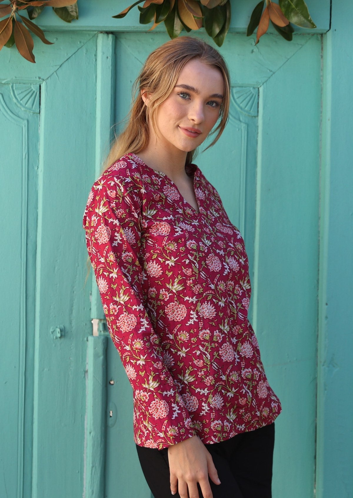 Model wearing long sleeved 100% cotton top with round neckline and V cutout