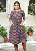 Model wears a knee length cotton dress with 3/4 sleeves, round neckline and pockets.