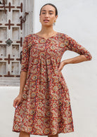 Model wears 100% cotton, midlength dress with earthy floral print, 3/4 sleeves and pockets.