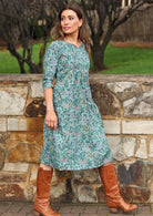 Model wears below knee length cotton dress with 3/4 sleeves,  pockets and empire waist.