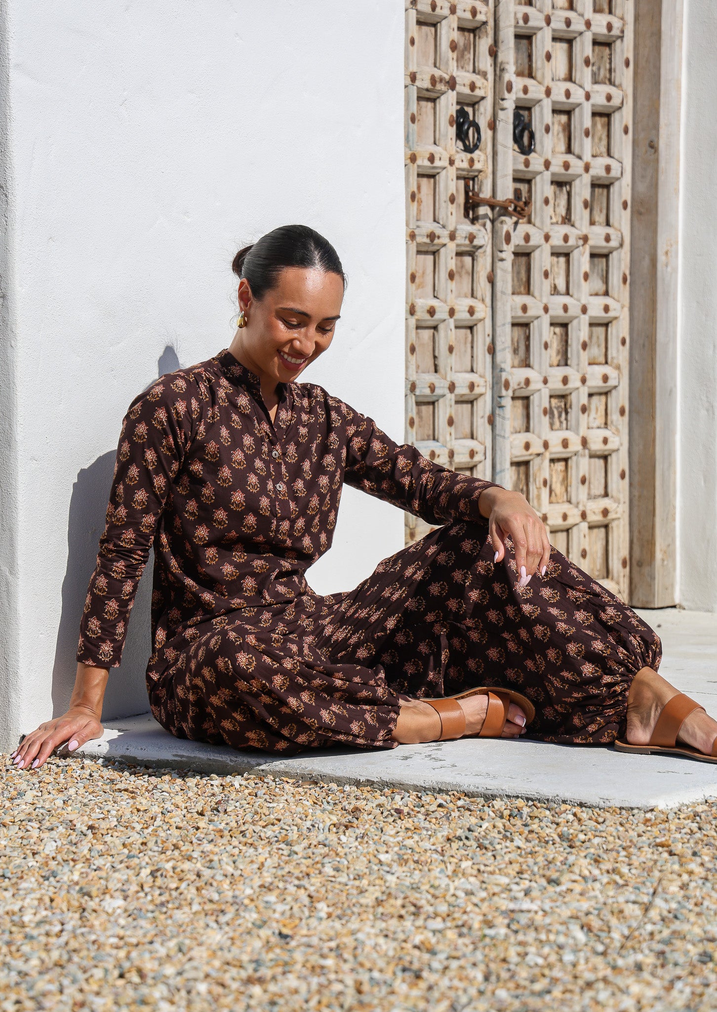 Woman wears 100% cotton long sleeve tunic and pants in same brown based floral print.