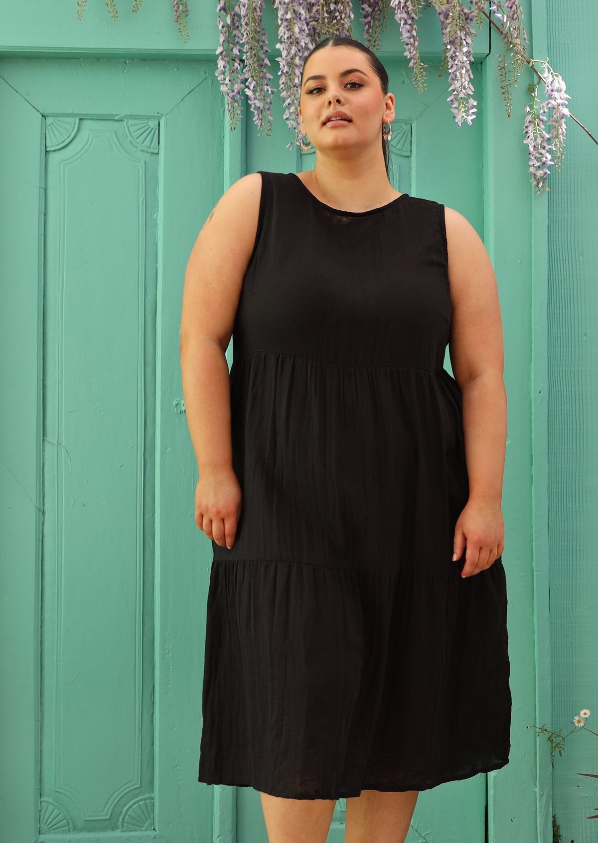 Plus sized woman wearing below knee cotton black dress