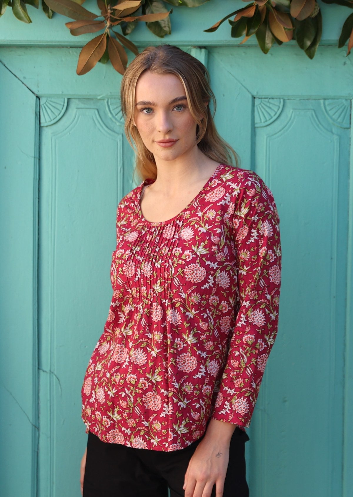 Model flaunting a beautiful cranberry based cotton top with floral print in pink, white and green.