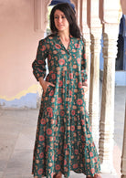 Model wears green cotton three tiered maxi dress with 3/4 sleeves and buttoned bodice.