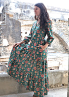 Model flaunting a jade green based floral printed cotton dress with 3 tiers, V neckline and pockets