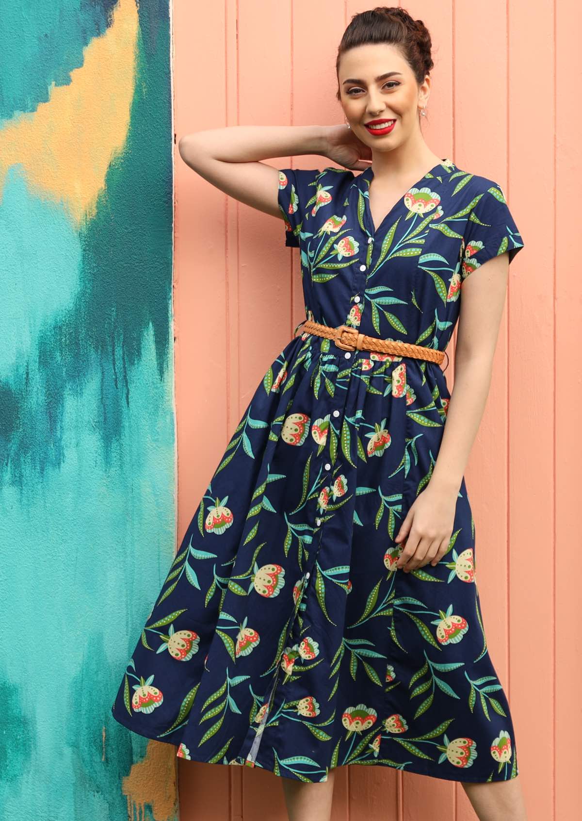 Model wears dress with a removable waist tie.