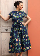 Model wears a dress with buttons down the front.