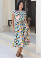Woman standing in cotton 50's style button through dress with mandarin collar,  in pastel colours