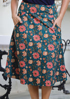 Knee length cotton skirt in pink, orange and cream floral print on deep green base.
