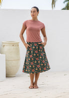 Model wears a beautiful deep green floral   skirt with pockets, wide waistband and side zipper.