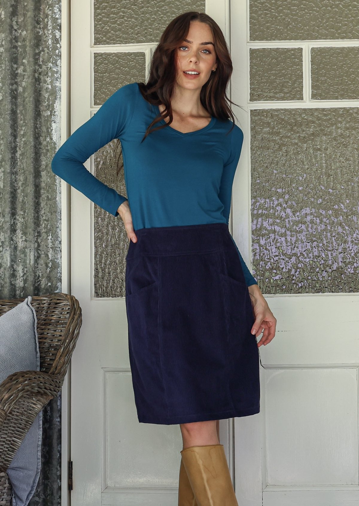 woman wearing a cotton corduroy skirt in and basic top with knee-high boots