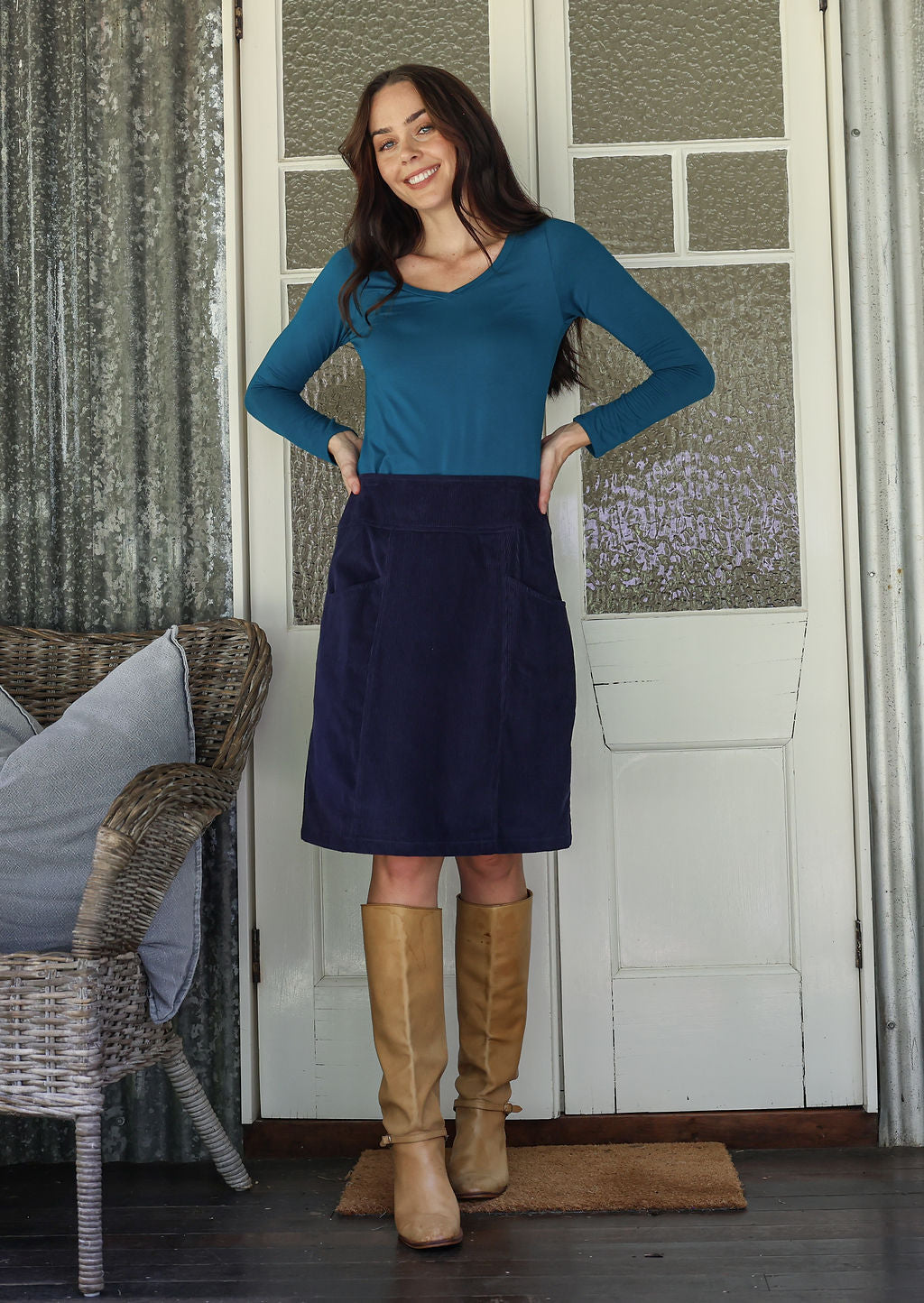 woman wearing a cotton corduroy skirt in deep, rich, and slightly muted navy blue paired with a basic top