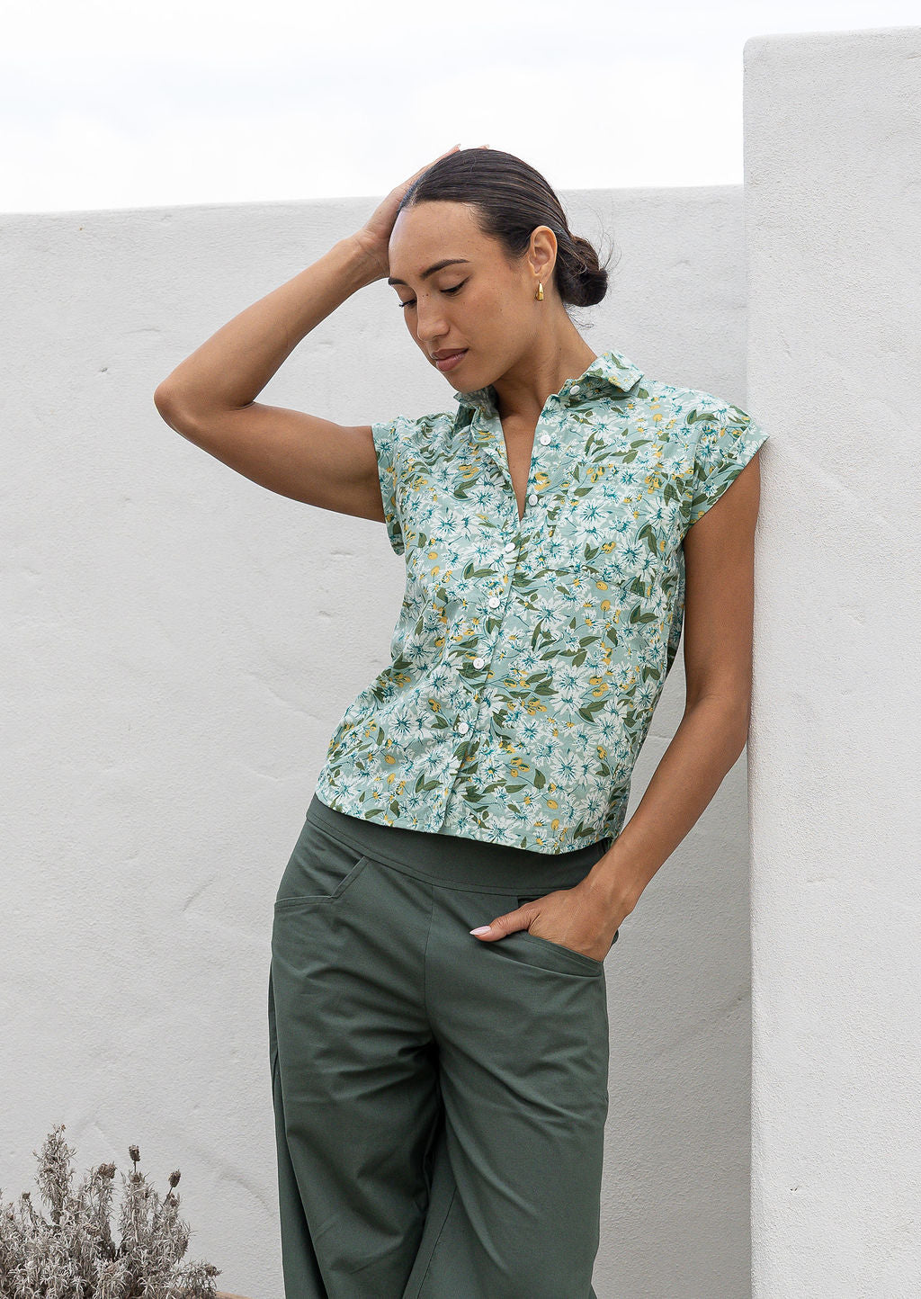 Model standing, wearing a 100% lightweight cotton button up shirt with folded cuff sleeves and collar