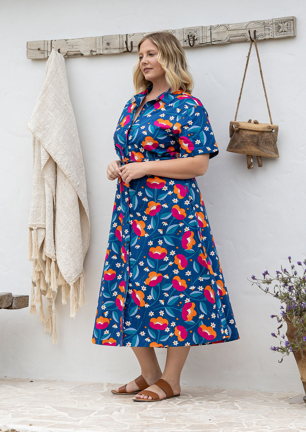 Model standing wearing a floral printed shirt dress with detachable fabric belt and short sleeves