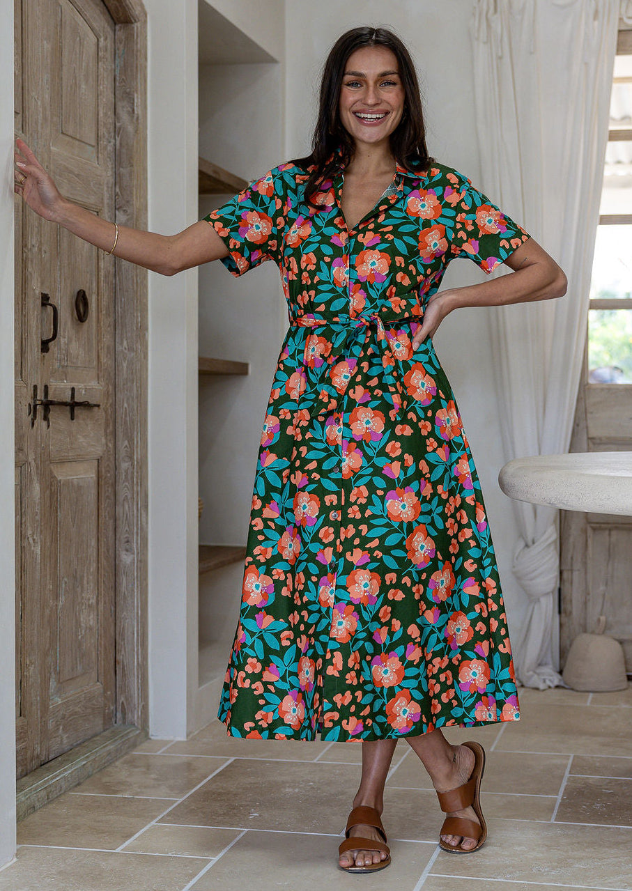 Model standing wearing a floral printed shirt dress with detachable fabric belt and short sleeves
