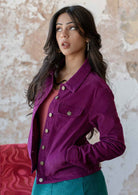 Woman with hands in pockets wearing 100% corduroy jacket with breast and front pockets, brass buttons, collar