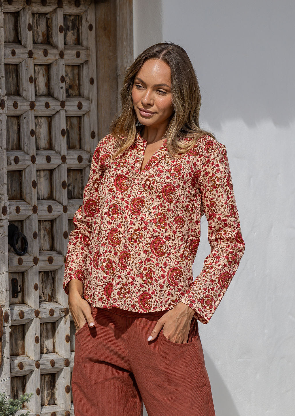 Woman wearing a 100% cotton top in cream based floral print with V neckline