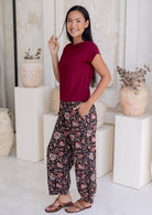 Model stands sideways wearing a sleeveless top paired with printed wide leg cotton pants featuring pleated ankles and pockets